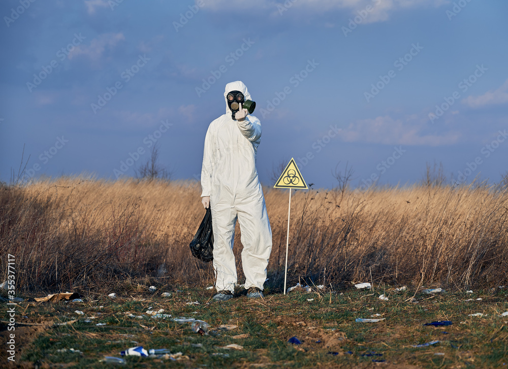 Full length of angry environmentalist in protective suit standing in ...
