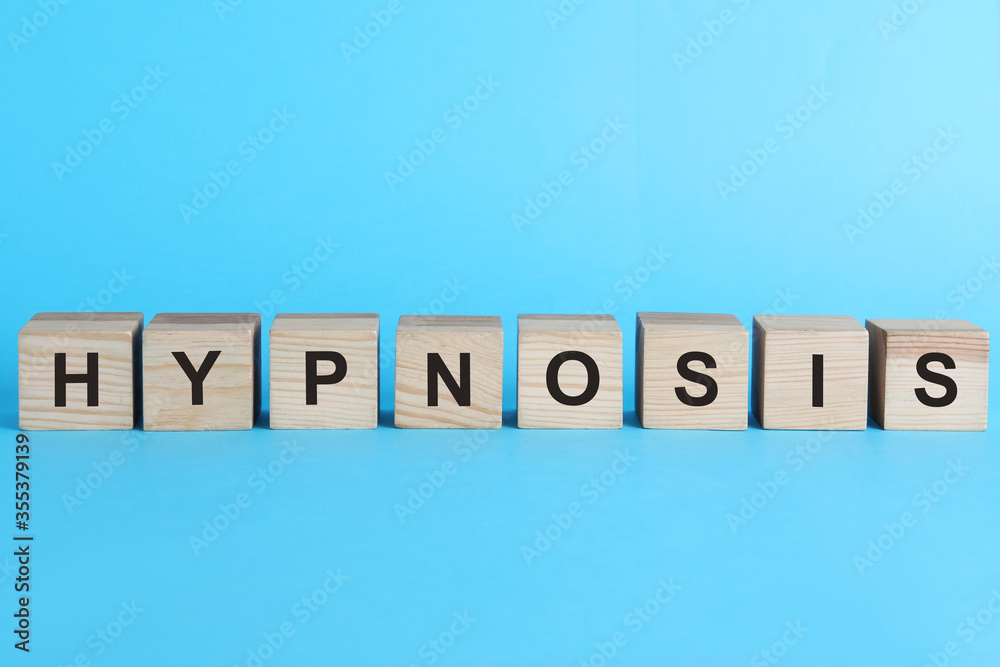 Wooden blocks with word HYPNOSIS on light blue background Wooden blocks with word HYPNOSIS on light blue background