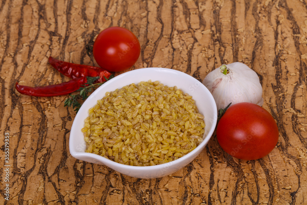 Raw bulgur in the bowl with tomatoes and garlic Raw bulgur in the bowl with tomatoes and garlic