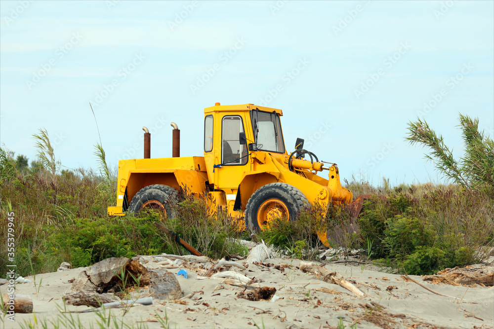 bulldozer on the sea shore to move the sand and clean up before