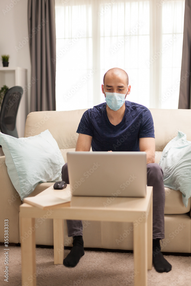 Man sitting on couch in time of a video call during global pandemic.