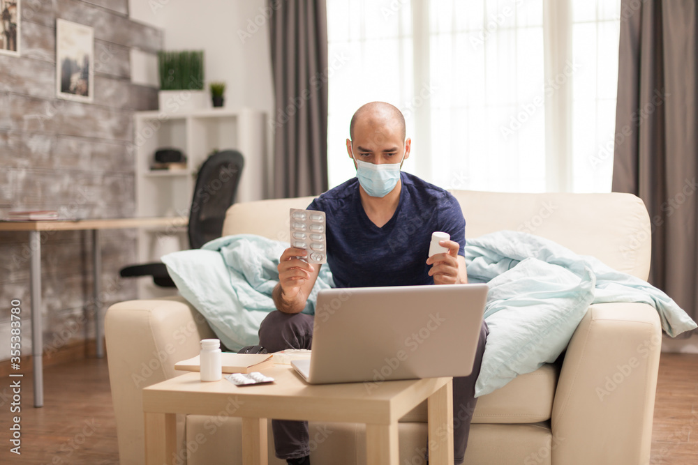 Sick man holding pills in hands talking with doctor on video conference during global pandemic. Sick man holding pills in hands talking with doctor on video conference during global pandemic.