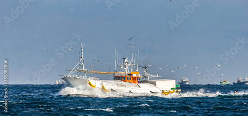 Fotografiet Fishing boat returns after fishing to its port