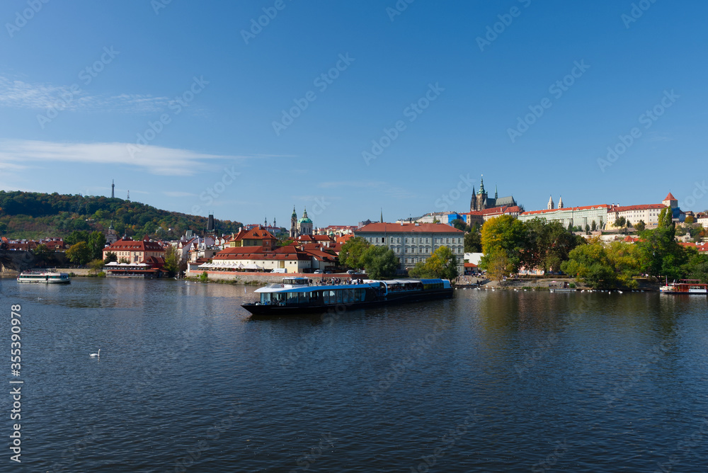 Pleasure boat on the Vltava pier in the fall. View of Prague.