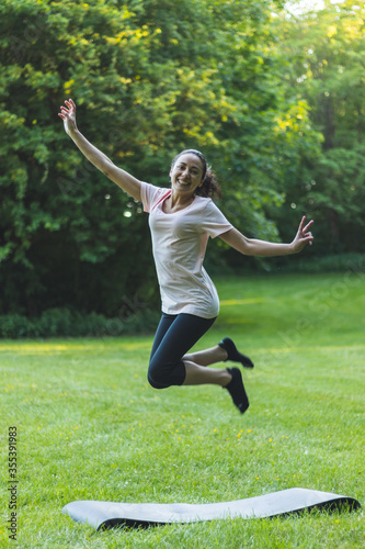 Happy, young woman jumping in the park