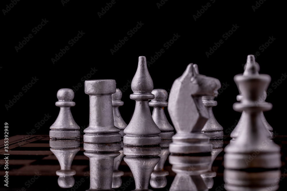 Chess pieces in silver on a black background. Board game chess.