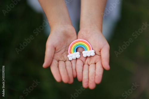 Colorful rainbow in children's hands, a child holds a rainbow in his hands, the concept of LGBT and freedom