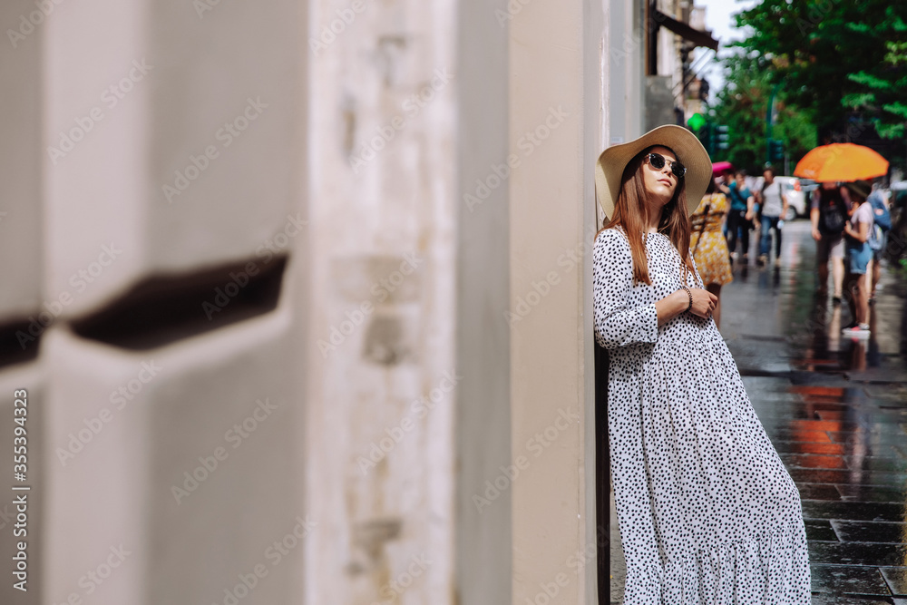 Portrait of a girl in a white dress and hat. Stylish woman on the streets of Rome. place for text