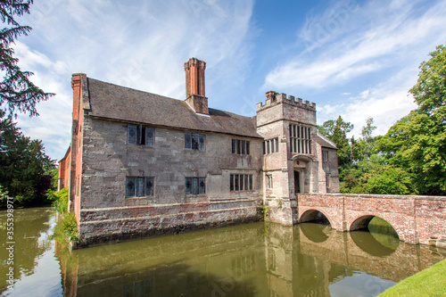 A tudor, timber-framed manor house with a moat and walled gardens, plus Elizabethan interiors.