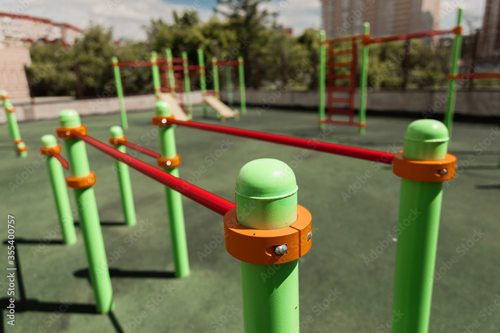 green and red horizontal bars on a playground in the summer
green and red horizontal bars on a playground in the summer