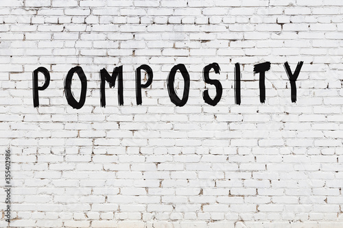 Word pomposity painted on white brick wall