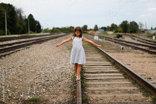Children walk on the rails of the railway, dangerous games and child safety © natalialeb