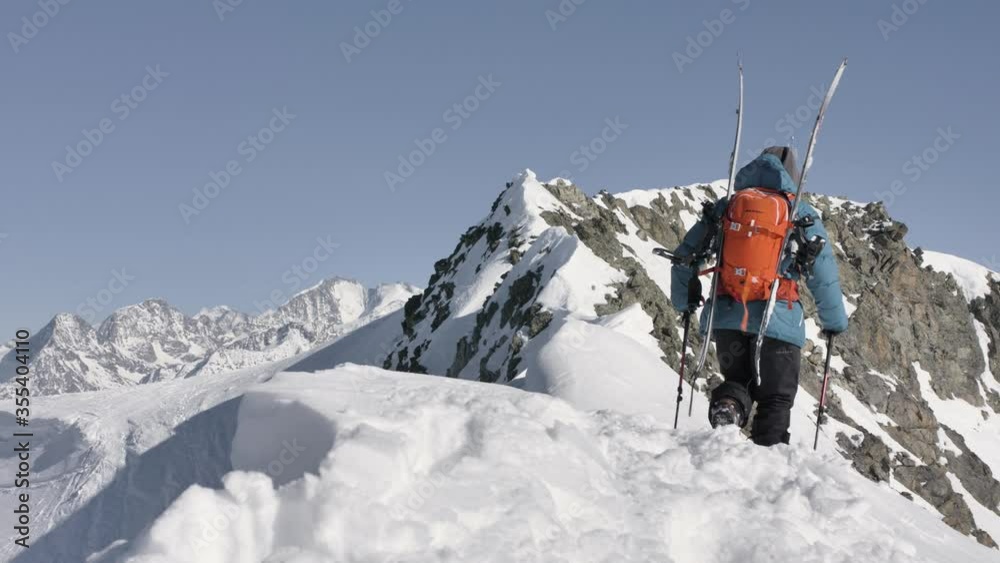Splitboarder hiking on top of a mountain in Switzerland. Splitboarder hiking on top of a mountain in Switzerland.