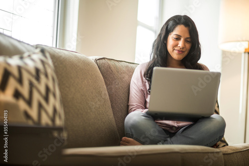 Young woman working at home sitting on a sofa. photo