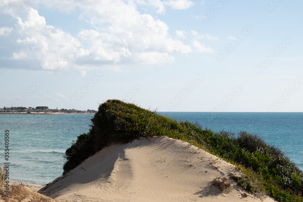 Seascape of the Jonio sea seen among the sand dunes, Tarantina coast in Puglia in southern Italy.