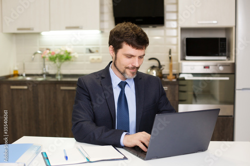 man in a suit works at a computer at home. Business communication concept.