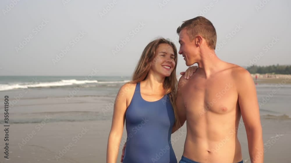 A young couple in love walks on a sandy beach. Family of newlyweds on the sea A young couple in love walks on a sandy beach. Family of newlyweds on the sea