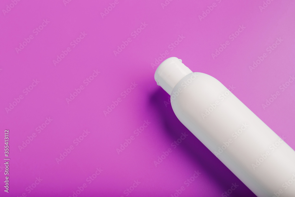 White bottle on pink background. Free space for text. White bottle on pink background. Free space for text.