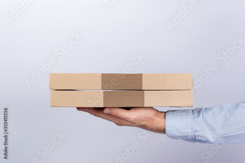 Pizza boxes in male hands. White background. Side View. Courier delivery © somemeans