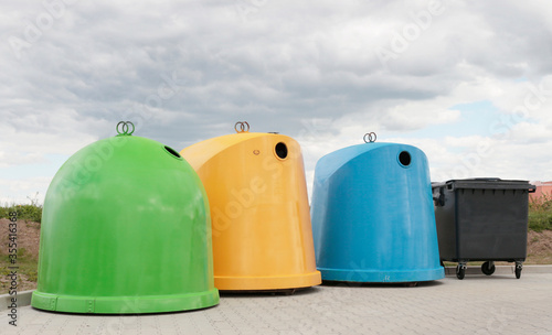 big waste containers: green, yellow, blue and black