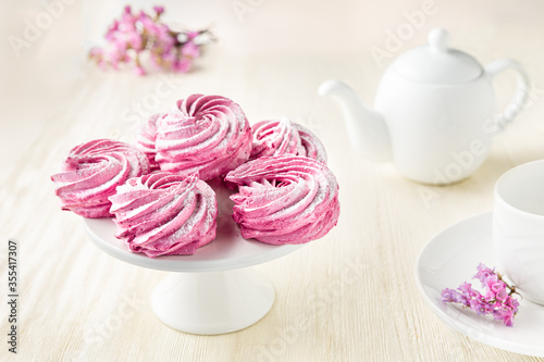 Pink meringue with flowers and white teapot