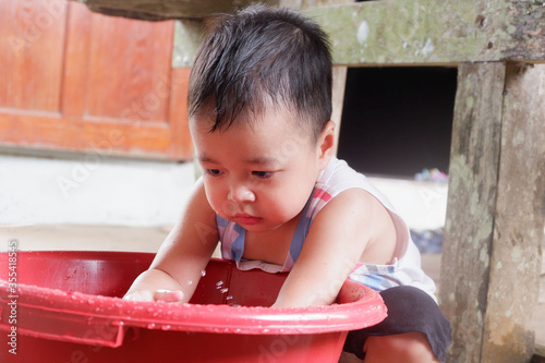 An Asian boy is playing with a water balloon. Playing is learning.