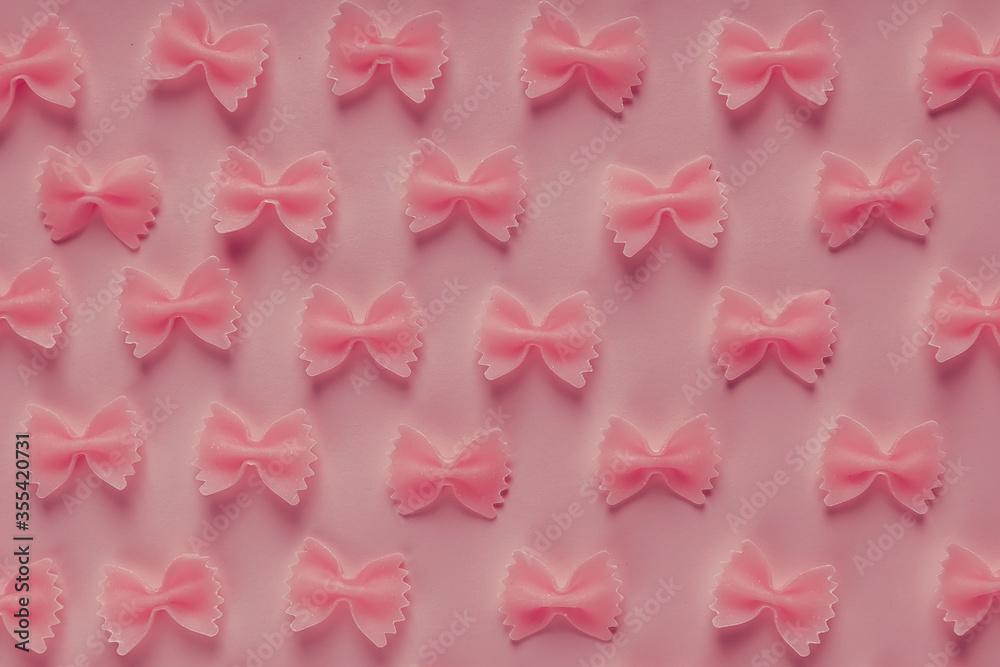 Pink spiral pasta on a pink background, Italian traditional food. View from above. Art and design.