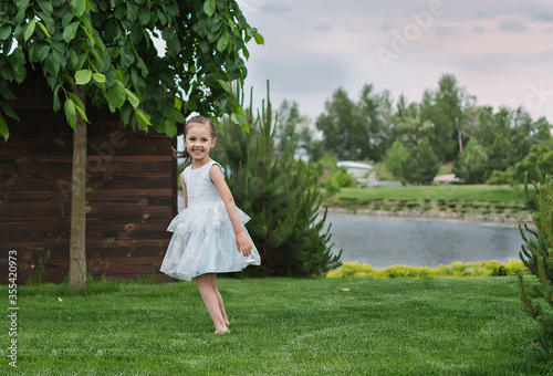 happy little girl on the beach. little girl in a white dress. little girl lying on the grass. little girl walking on the road