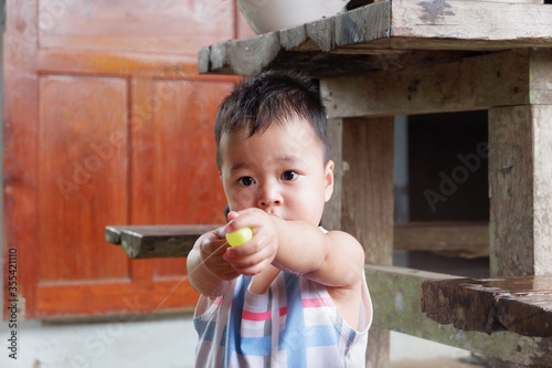 An Asian boy is playing with a water balloon. Playing is learning.