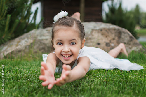 happy little girl on the beach. little girl in a white dress. little girl lying on the grass. little girl walking on the road