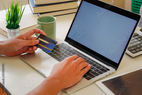 Hands holding credit card and using laptop. Online shopping