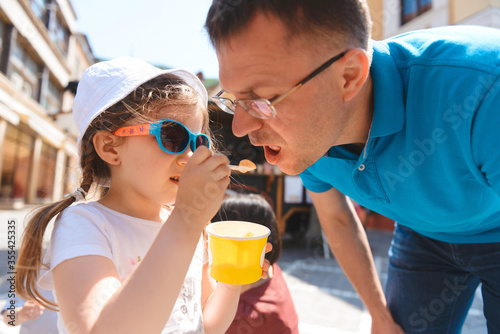 girl feeding father with ice cream