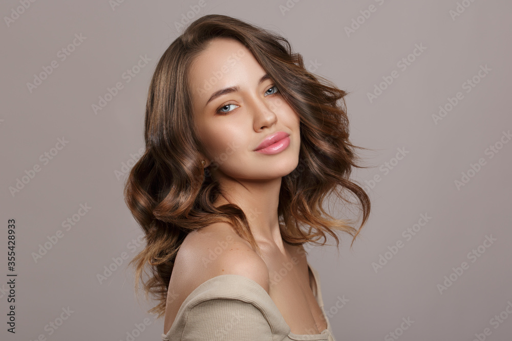 Naklejka premium Young beautiful woman with wavy brown hair. thick luxurious hair. hairstyle. Copycpase