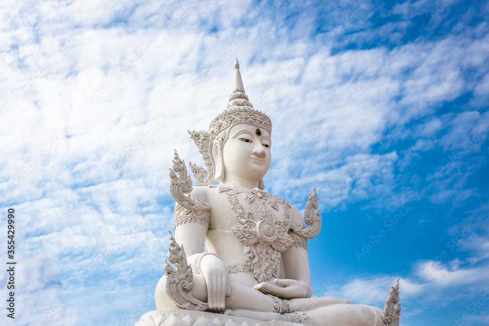 White Buddha on blue sky and cloud background