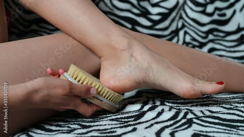 Girl massages the heels of the feet with a brush