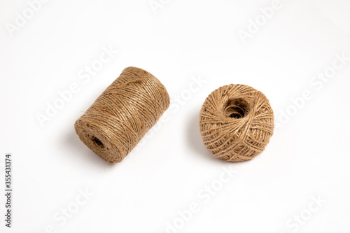 A skein of linen string, cord isolated. Coil of twine. Jute rope. Hemp thread isolated. A skein of brown wool for knitting on a white background. High-resolution photo.