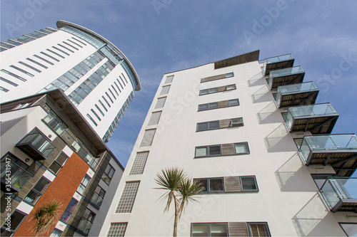 Modern apartment building with balconies and blue sky at the SA1 development in Swansea. 