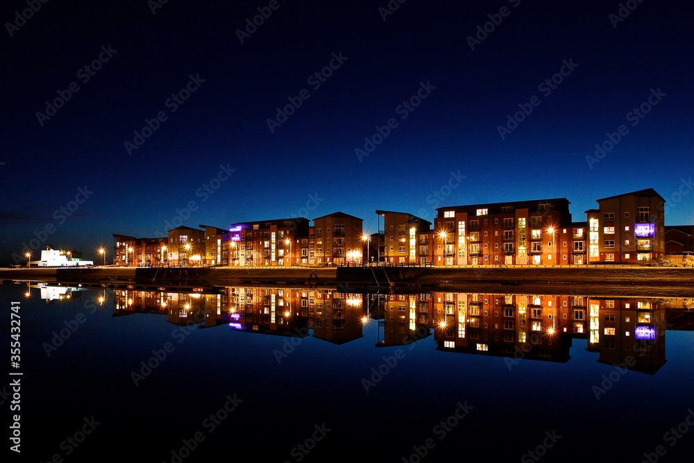 Quayside Apartment Building at night with reflections in the water. Quayside Apartment Building at night with reflections in the water.