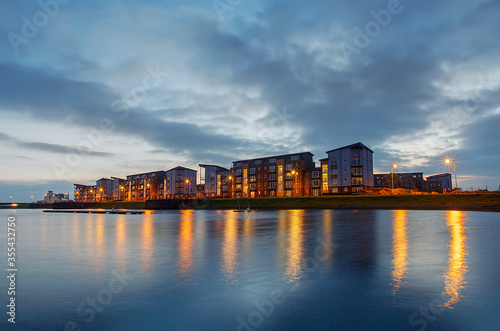 Quayside Apartment Building at night with reflections in the water. 