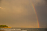 Sunset and rainbow in Platja Llarga beach, Tarragona, Spain