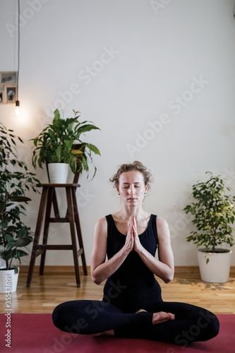 Girl does yoga in the apartment by video link in a beautiful designer apartment. Girl watches a tutorial on a laptop, athlete do yoga at home on self-isolation