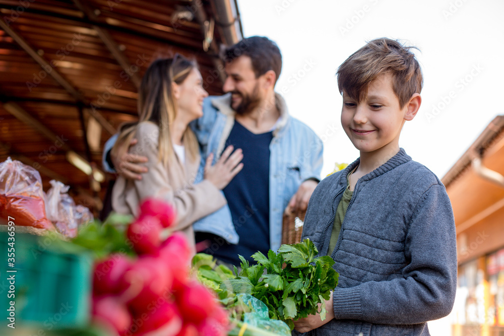 Son looking at groceries while his parents are hugging Son looking at groceries while his parents are hugging