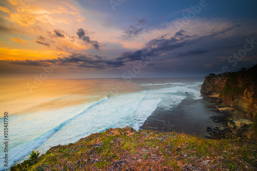 Seascape. Spectacular view from Uluwatu cliff in Bali. Sunset time. Blue hour. Ocean with motion foam waves. Waterscape for background. Nature concept. Soft focus. Slow shutter speed.