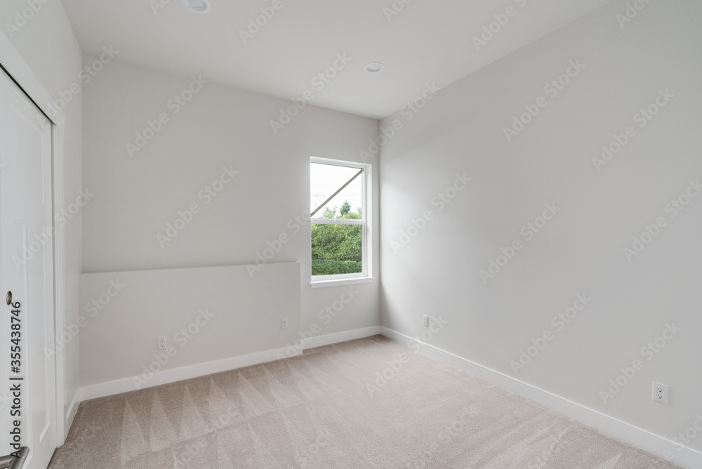 Empty room with a window, white painted walls, carpet floor and built-in closet Empty room with a window, white painted walls, carpet floor and built-in closet
