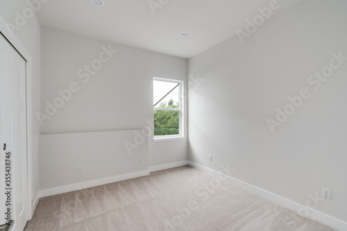 Empty room with a window  white painted walls  carpet floor and built-in closet