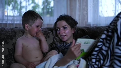 Mom with a child reading a book in the dark. Mom develops a child's horizons