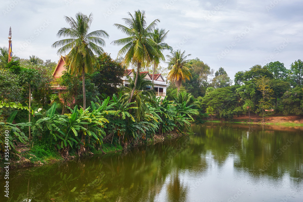 Scenery view of the lake with a house behind the palm trees in Cambidia