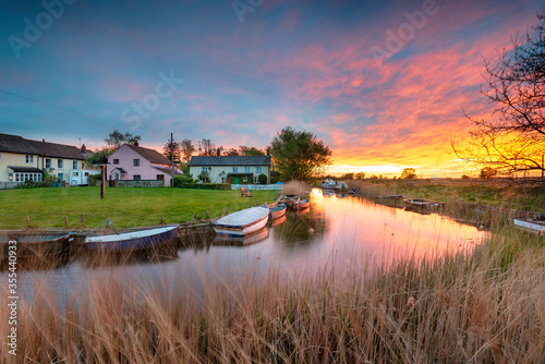 Stunning sunset over the village green and boats on the river at West Somerton photo