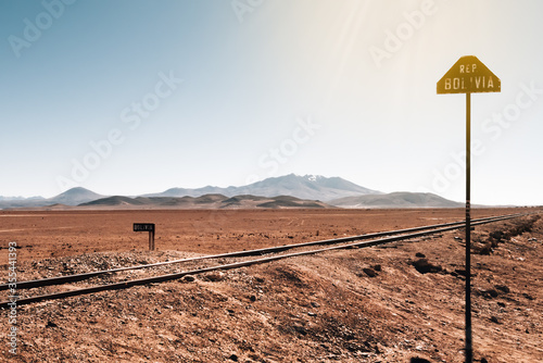 Railway track in the Andes with Bolivian railway signal with sun