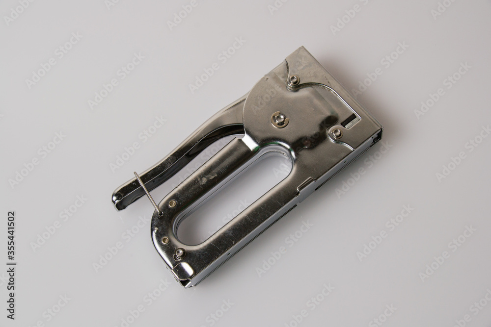 The concept of repair and construction. Construction stapler on a gray background view from the top The concept of repair and construction. Construction stapler on a gray background view from the top